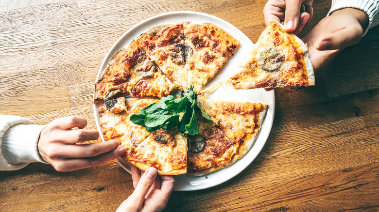 two friends sharing a rustic pizza