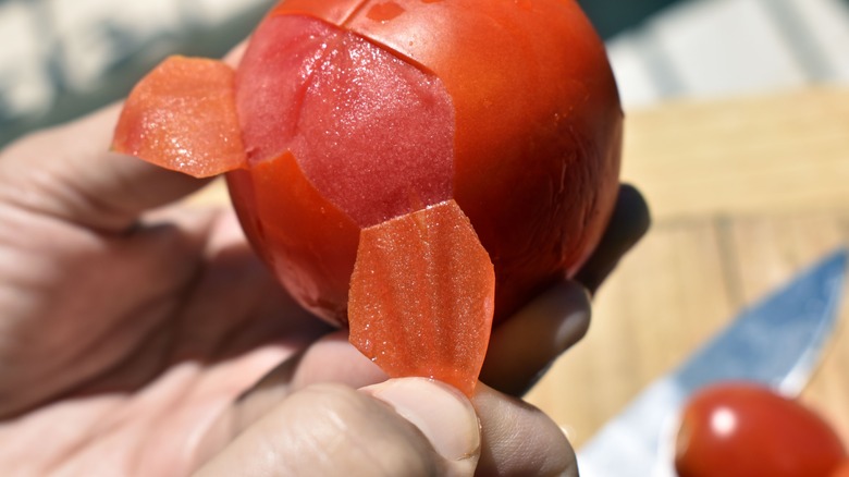 tomato being peeled manually