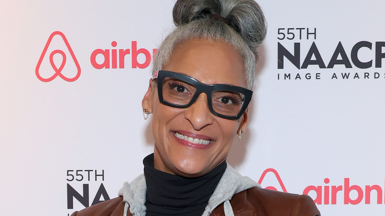 Carla Hall, hair up, black glasses