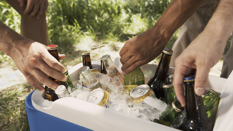 hands grabbing beer from a cooler