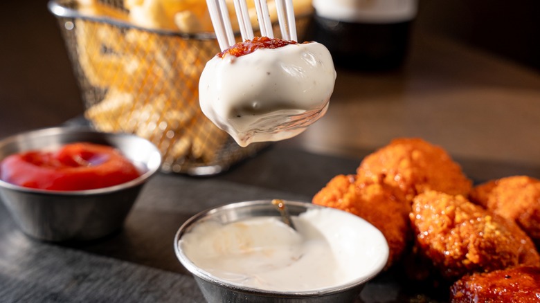 Fork dipping appetizer into a dish of ranch dressing